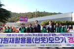 '자원재활용품(헌옷) 모으기 경진대회' 현수막 앞에서 '용당2동' 표지판을 들고 파이팅 포즈를 취하고 있는 목포시 관계자와 시민들.